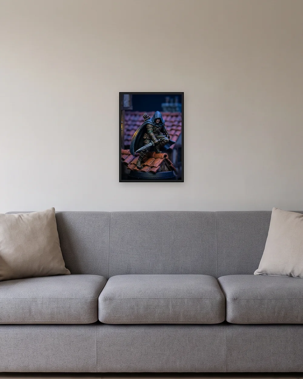 Framed print, 16.5 × 23.4 in (A2) in a black frame (17.5 × 24.3 in outside), on a wall above a gray sofa, shown to scale with example artwork